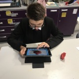 Photograph of a pupil making an animation movie using a school iPad and the Stickbot app