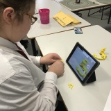 Photograph of a pupil making an animation movie using a school iPad and the Stickbot app