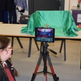 Photograph of a pupil making an animation movie using a school iPad mounted on a tripod and  green  screen background