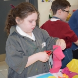 Picture of a pupil cutting a piece of pink material