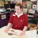 Picture of a pupil rolling clay with a rolling pin