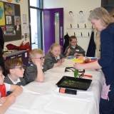 Picture of an artist explaining to pupils how to make print art