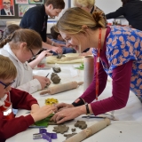 Picture of an artist and pupil working with clay