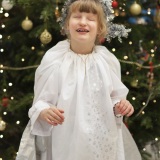 photograph of  a pupil dressed as an angel beside the Christmas tree