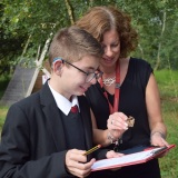 Picture of a teacher and pupil looking at an insect they had found