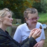 Picture of a teacher and pupil looking at an insect they had found