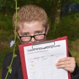 Picture of a pupil recording the colour of a flower they had found