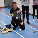 Picture of instructor explaining about hurling and the equipment used in the game