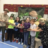 Picture of staff and several  pupils holding a large snake