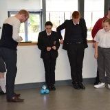 Picture of a teacher and students taken turns to program and move the Dash robot