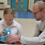 Picture of a teacher and student examining the Dash robot