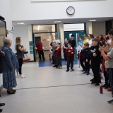 Picture of staff and pupils singing for the  Lord Lieutenant of County Antrim, Deputy Lord Lieutenant and Cadet.