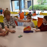 Photograph of a teacher and pupil enjoying a drink and a biscuit during a a game of  Uno