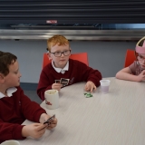 Photograph of pupil enjoying a drink and a biscuit