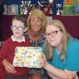 Photograph of a pupil and a teacher after he received his prize from the special guest