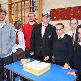 Group picture of the school leavers cutting the celebration cake