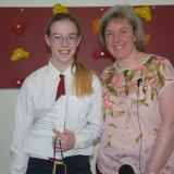 Picture of a school leaver being presented with a gift by  the school  principal