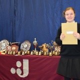 Photograph ofa pupil with their examination certificates