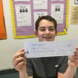 Photograph of a pupil holding the cheque they had written