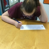 Photograph of a pupil writing a cheque