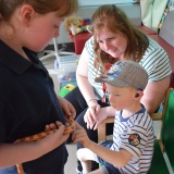 Photograph of pupils holding and petting owls and snakes.