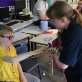 Photograph of pupils holding and petting owls and snakes.