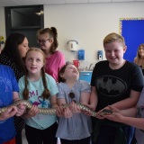 Photograph of pupils holding and petting owls and snakes.