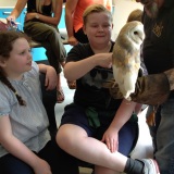 Photograph of pupils holding and petting owls and snakes.