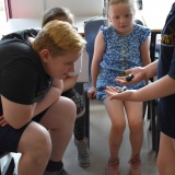 Photograph of pupils holding and petting owls and snakes.