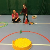 Photograph of a pupil being timed at throwing bean bags into a container