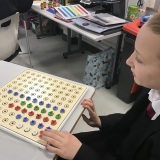 Photograph of a pupil using a coloured peg board