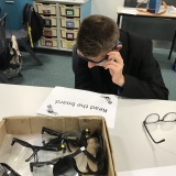 photograph of pupil wearing glasses that simulated being visually impaired while trying to complete a task