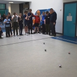 Photograph of  pupils controlling  several sphere shaped  robot with iPads